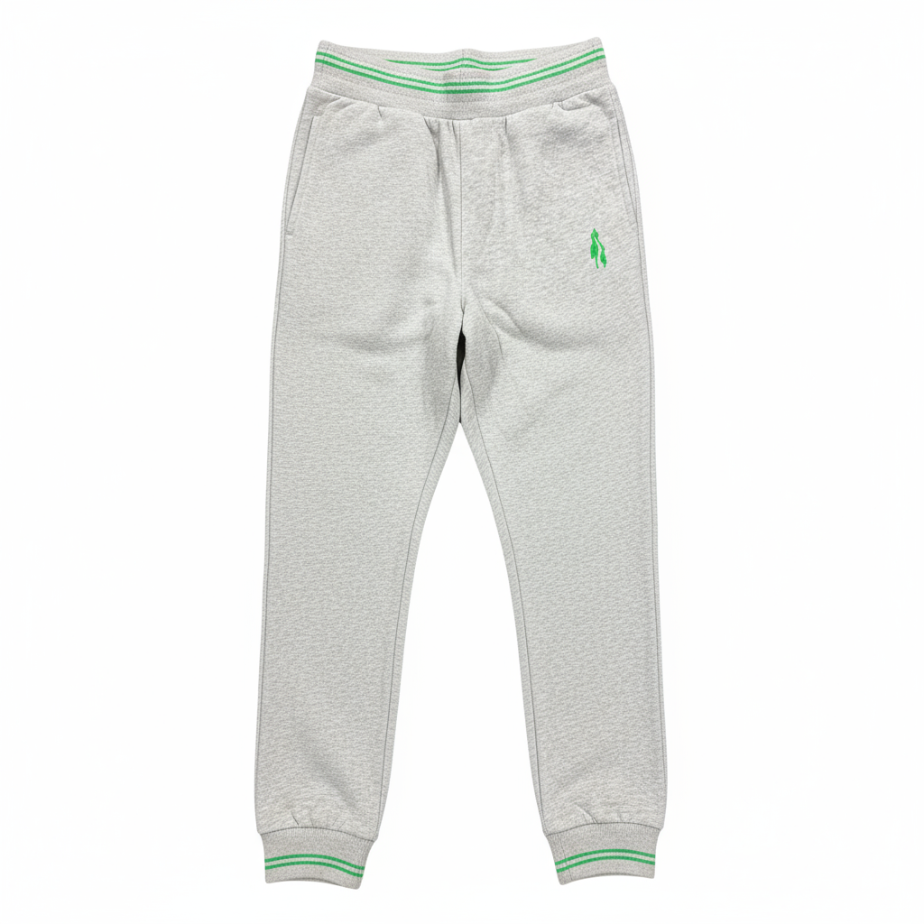 Grey sports trousers with green stripes and a logo on the left leg, displayed in a packed state with a visible green and white striped fabric on top.