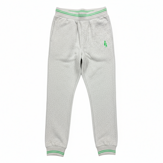 Grey sports trousers with green stripes and a logo on the left leg, displayed in a packed state with a visible green and white striped fabric on top.