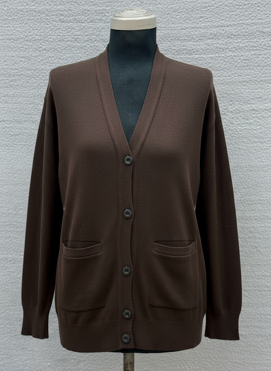 Dark green cardigan on a mannequin against a textured gray background