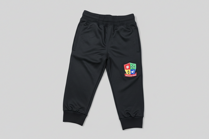 Black tracksuit pants with a colorful logo on a light wooden floor.
