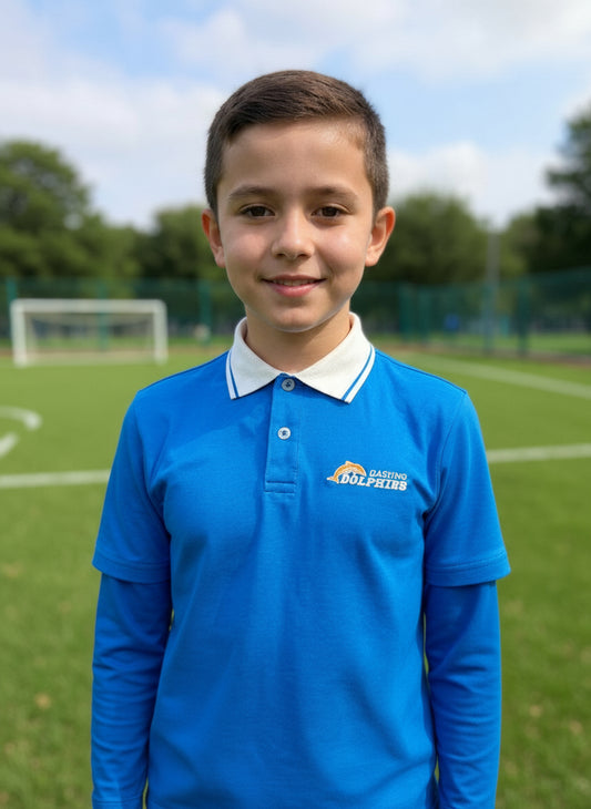 Young boy wearing a full-sleeve blue polo shirt with a logo on a sports field